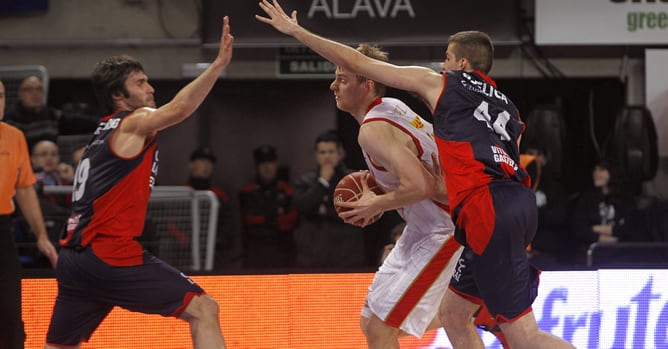 El pívot holandés del CAI Zaragoza, Henk Norel, avanza ante la defensa del alero Fernando San Emeterio y el alero serbio Nemanja Bjelica