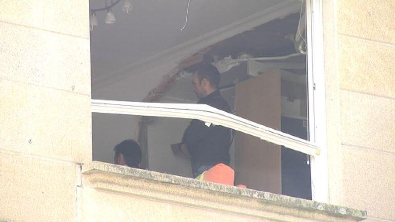 Miembros de la policía examinan el estado en el que quedó el interior d ela vivienda afectada por la explosión