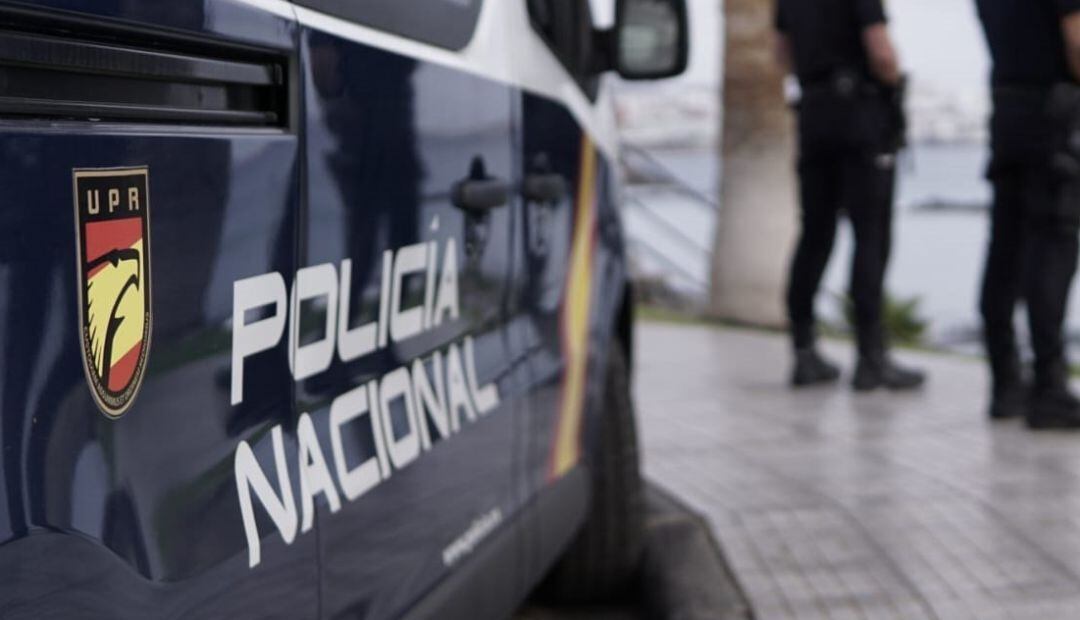 Agentes de la Policía Nacional junto a un coche patrulla