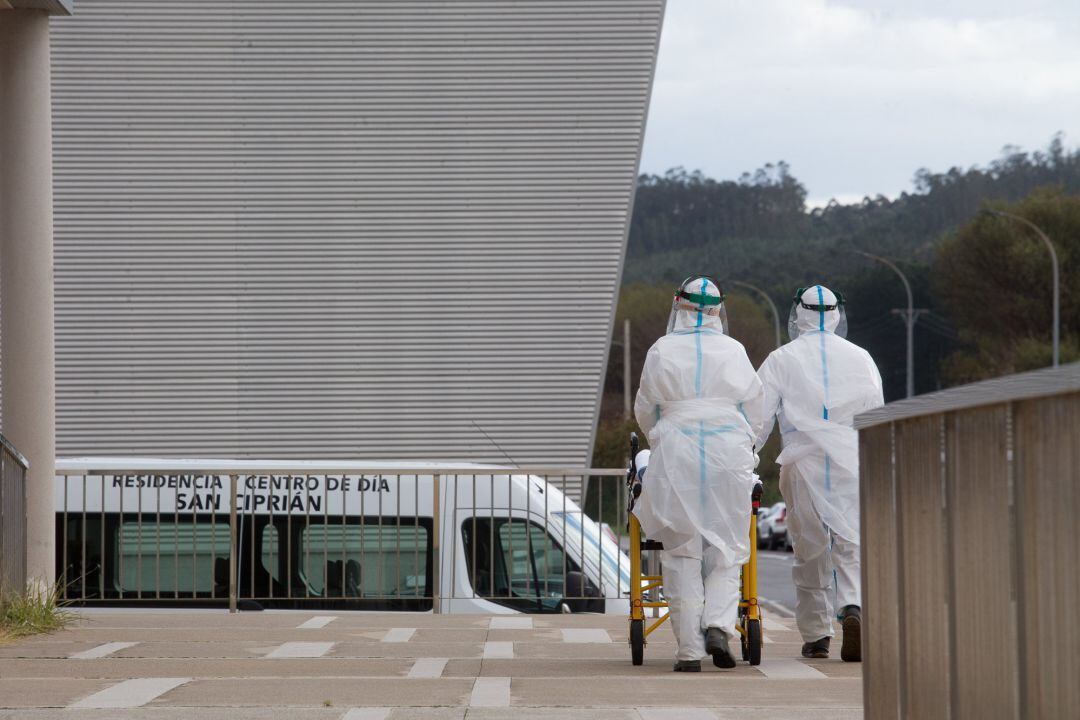 Dos trabajadores sanitarios totalmente protegidos acuden a una residencia de ancianos.