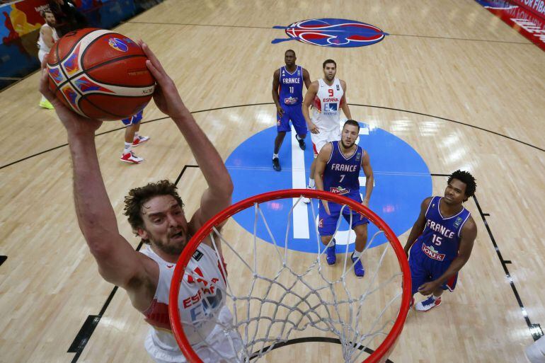 El pívot de la selección española Pau Gasol (i) machaca la canasta francesa, durante el partido Francia y España en el pabellón Pierre Mauroy, en Lille