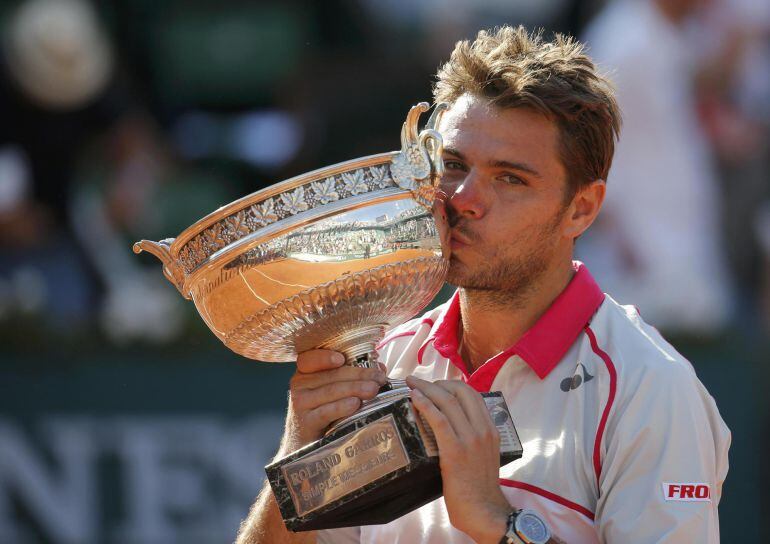 Stan Wawrinka of Switzerland kisses the trophy as he poses during the ceremony after winning the men&#039;s singles final match against Novak Djokovic of Serbia at the French Open tennis tournament at the Roland Garros stadium in Paris, France, June 7, 2015.  