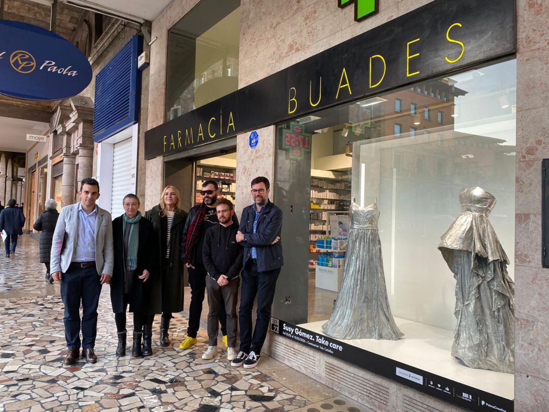 Dos vestidos plateados flotantes ocupan el escaparate de la farmacia