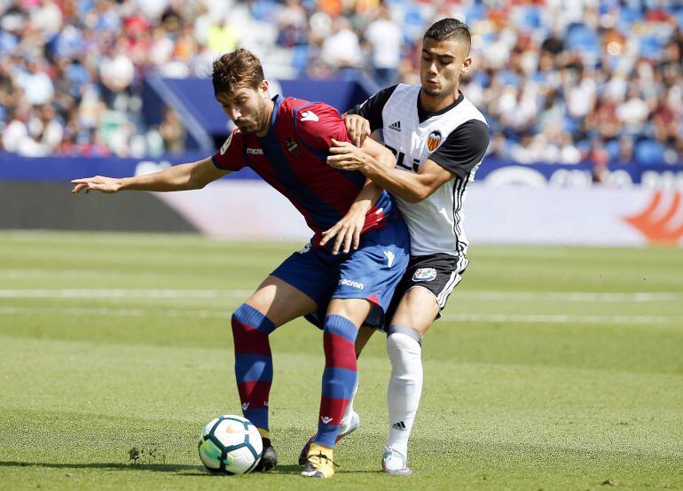 El centrocampista del Levante, José Gómez Campaña, controla la pelota ante el centrocampista del Valencia, Andreas Pereira.