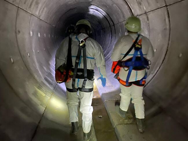 Los agentes de la Unidad de Subsuelo, junto a un equipo de Hora 25 en la red de saneamiento de Madrid