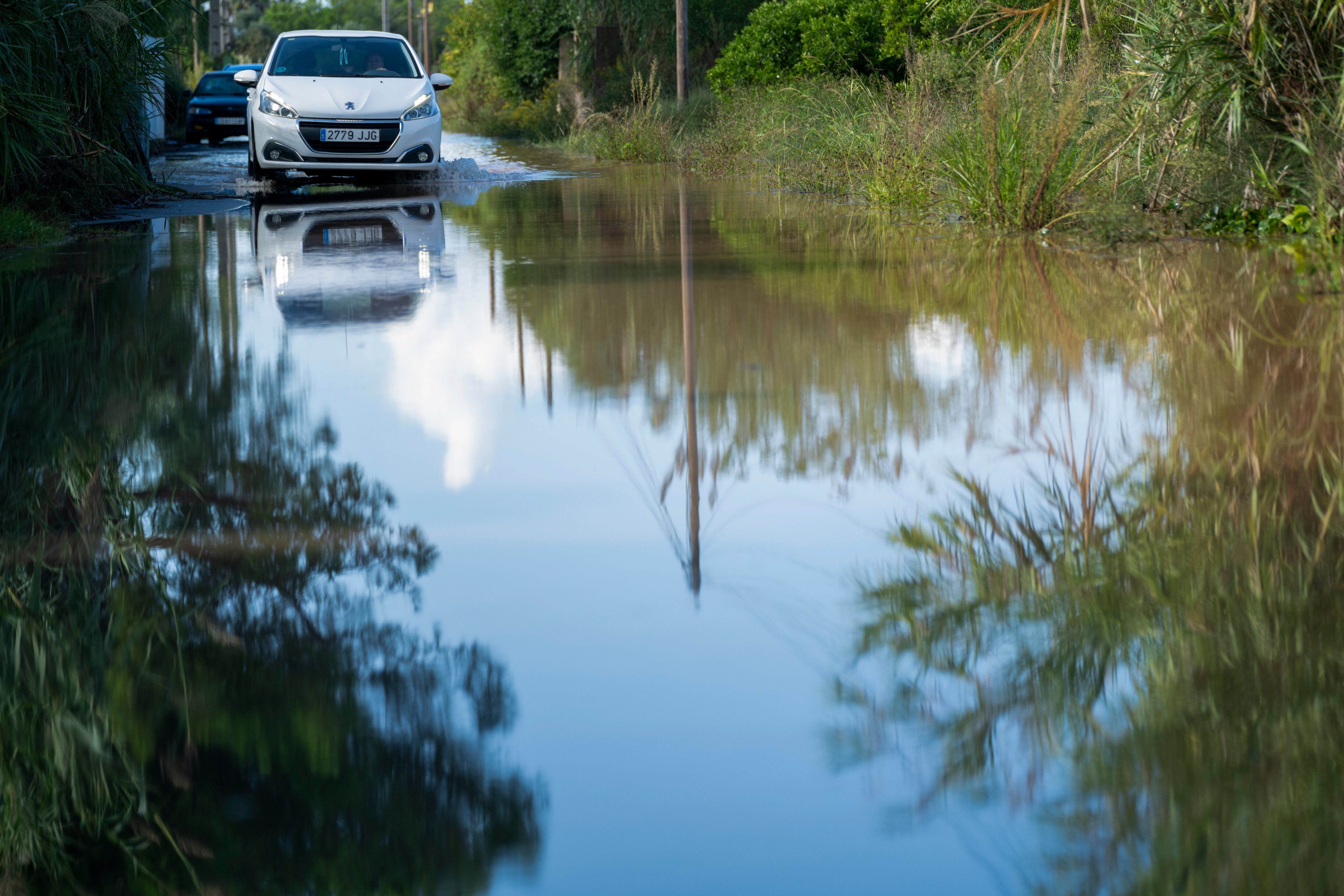 Un vehículo circula por una calle anegada en Burriana (Castellón)