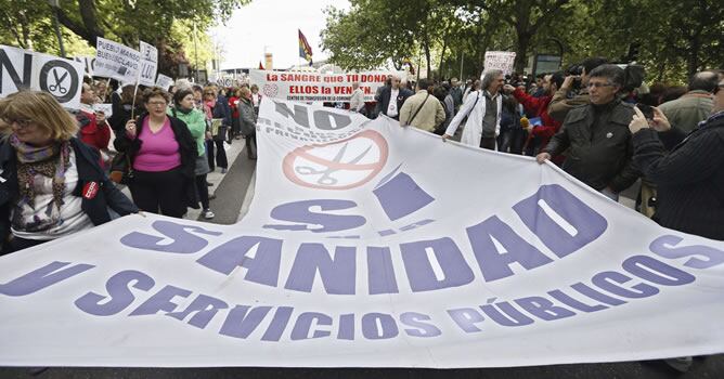 Varios manifestantes portan una pancarta durante la protesta convocada en Madrid por las mareas blanca (Sanidad), verde (Educación), naranja (Servicios Sociales) y roja (por la ciencia).