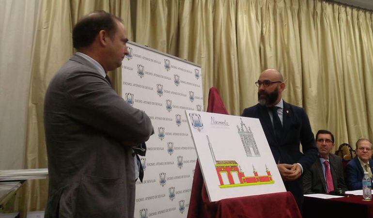 El hermano mayor del Gran Poder, Félix Ríos, a la izquierda de la imagen, atiende a la explicación del director artístico de la Cabalgata de Reyes Magos en Sevilla, Jesús Corral, sobre la carroza del Nacimiento, que esatará inspirada en la fachada de la Basílica de la Plaza de San Lorenzo