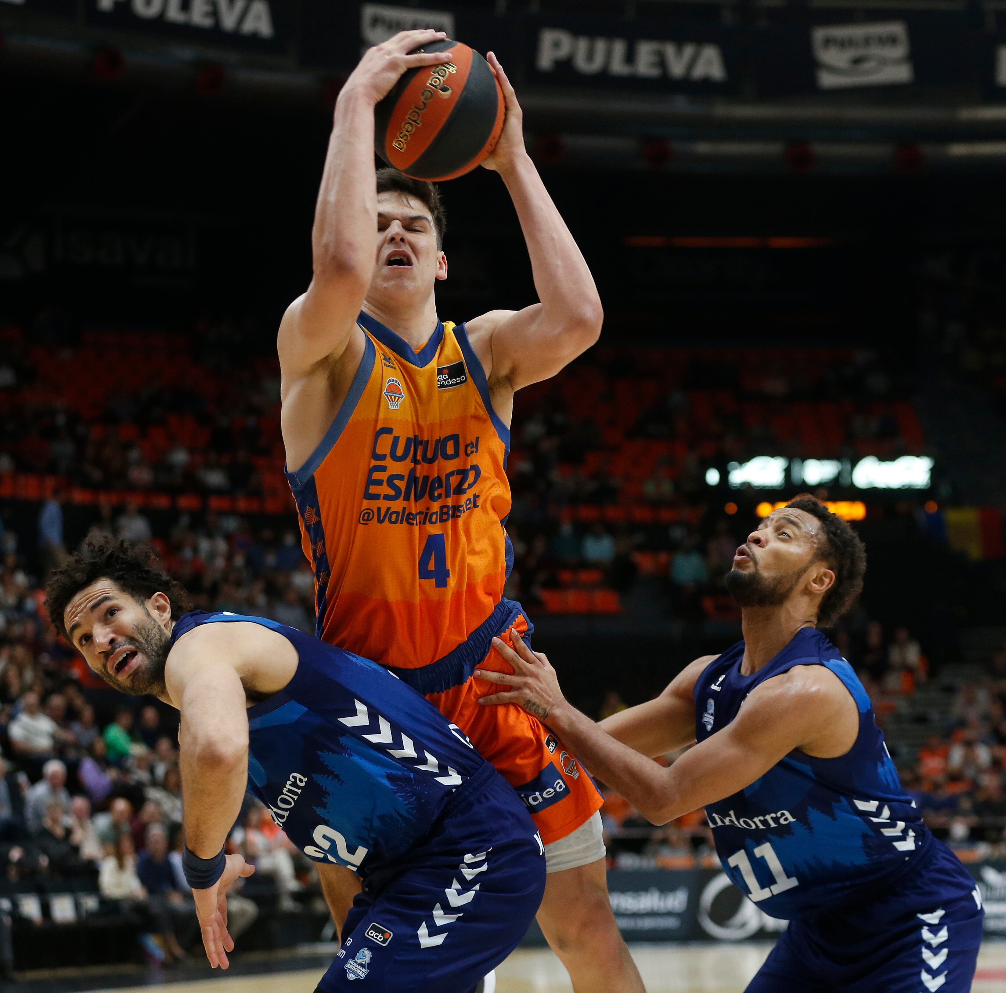 VALENCIA, 30/04/2022.- Los jugadores del Morabanc Andorra Drew Crawford (i) y Clevin Hannah bloquean al jugador del Valencia Basket Jaime Pradilla (c) durante el partido de Liga Endesa disputado en el pabellón de la Fuente de San Luis de Valencia. EFE/ Miguel Ángel Polo
