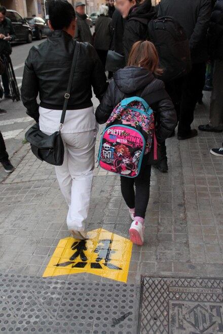 Una madre acompaña a su hijo en la ruta escolar segura de Torrefiel