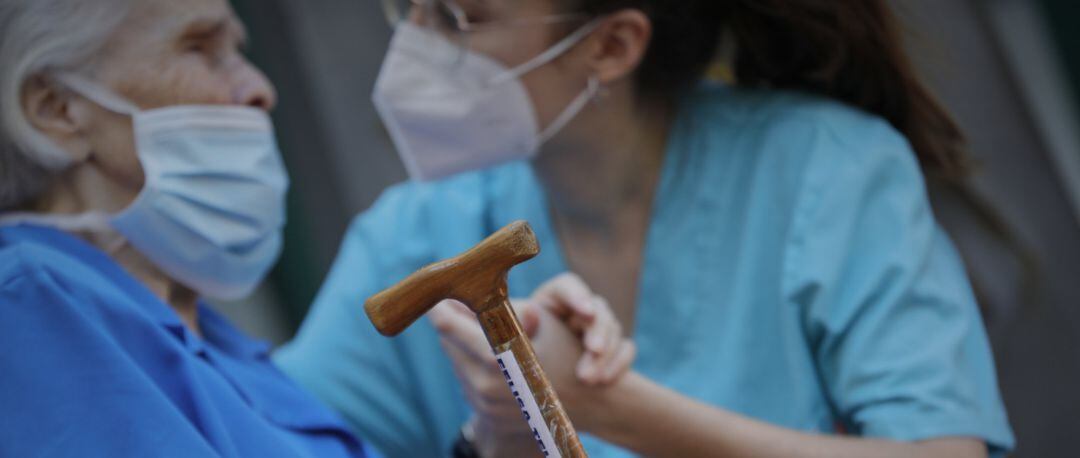 Una trabajadora y una anciana en una residencia