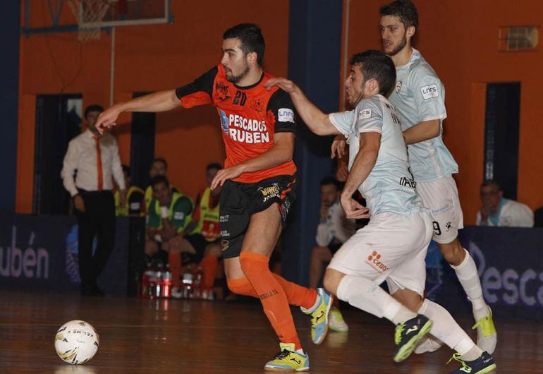 Chino se defiende de dos jugadores del Santiago Futsal