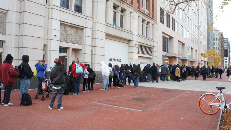 Personas sin hogar haciendo cola para entrar a la cena de Acción de Gracias organizada por Catholic Charities en Washington DC.