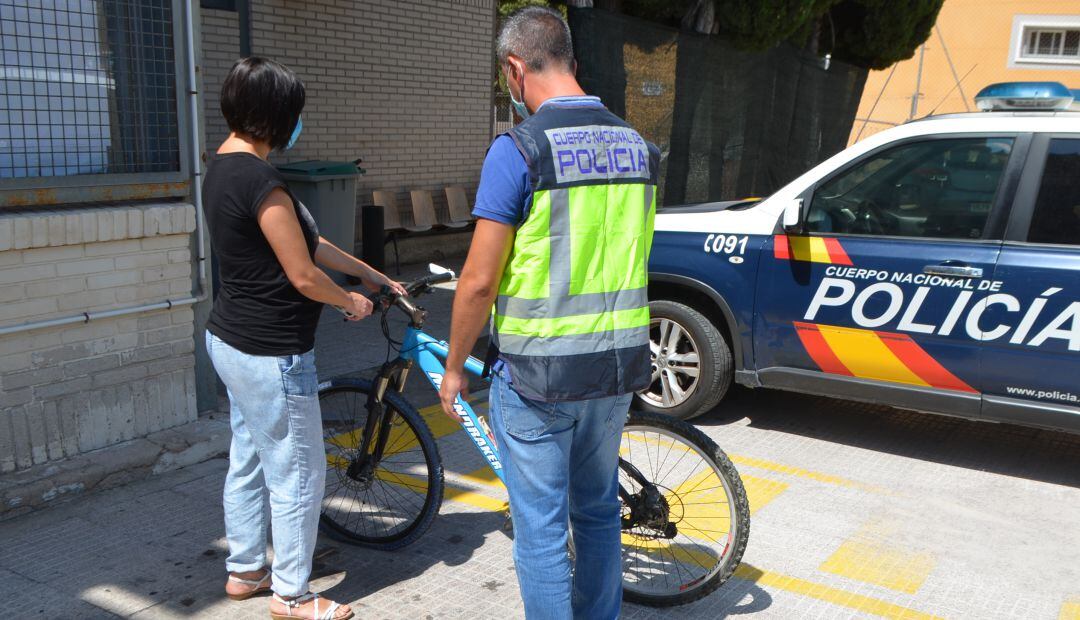 Un agenet de la Policía Nacional con uno de los objetos robados, una bicicleta