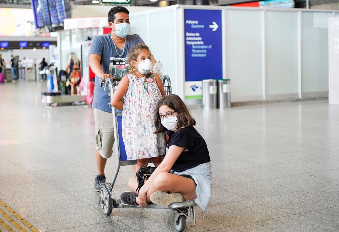 Una familia se dispone a coger un avión en el aeropuerto