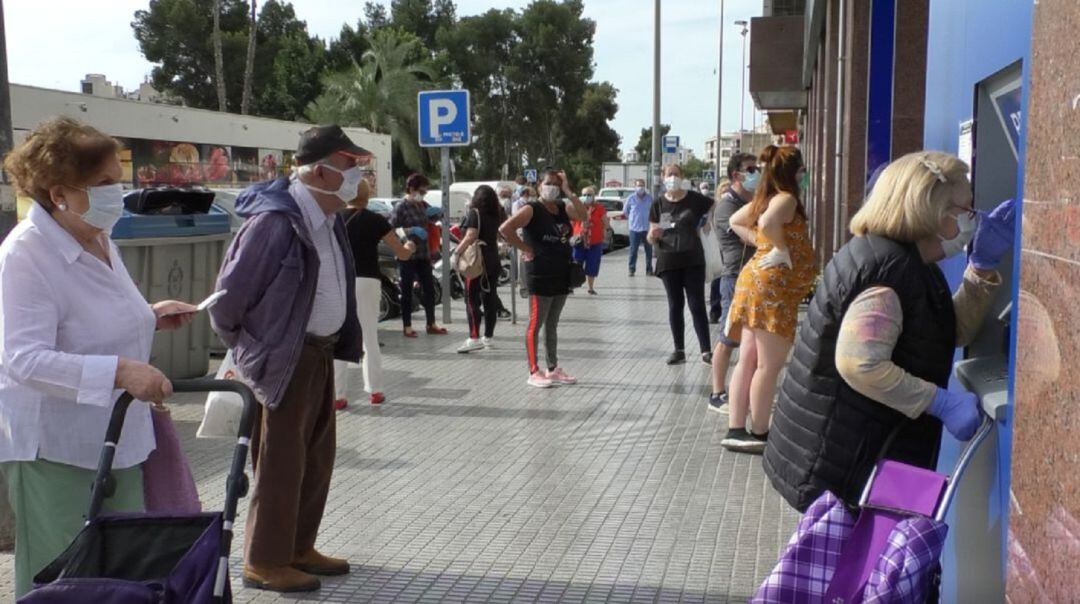 Gente esperando para entrar a una entidad bancaria en Elche