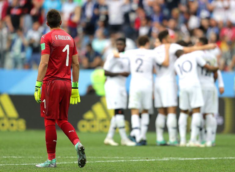 Muslera mira la celebración de los jugadores franceses tras el gol de Griezmann.