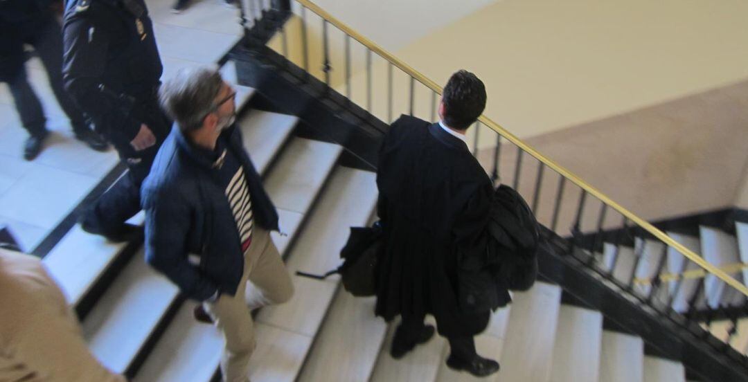 El acusado, con jersey a rayas, abandonando la Audiencia tras aceptar la condena.
