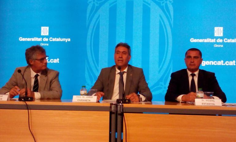 El conseller, al mig, en una roda de premsa.