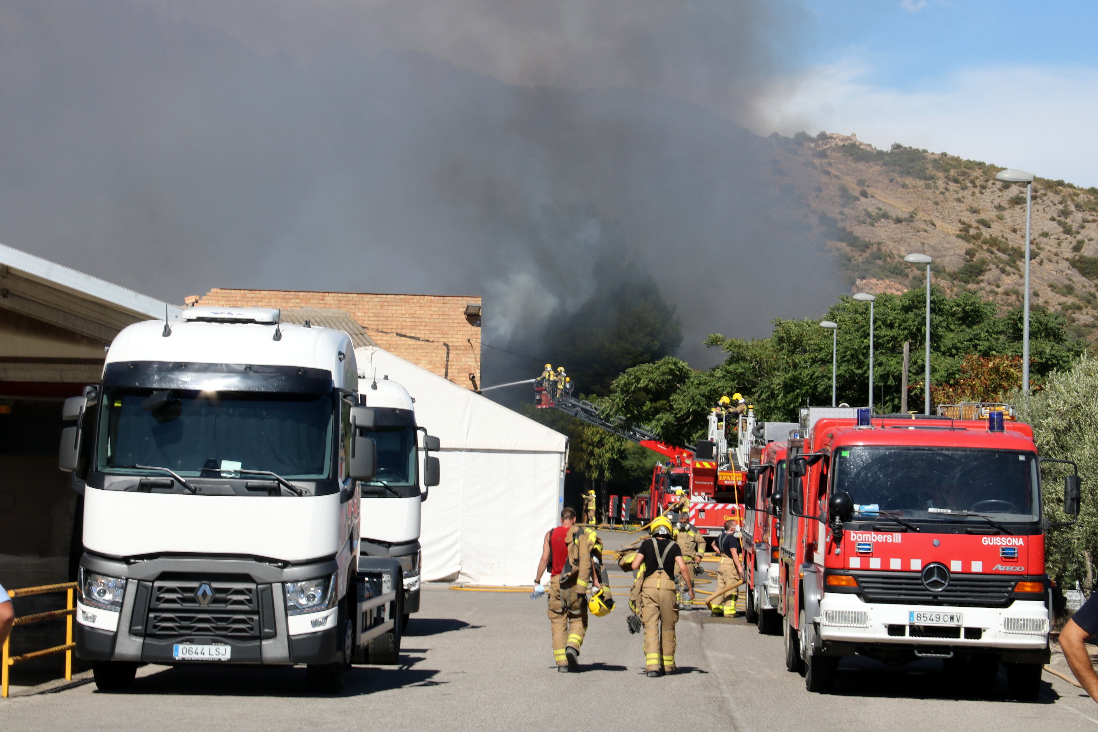 Tasques d'extinció de l'incendi en una nau d'una fàbrica de mobles d'Artesa de Segre. Foto: ACN.