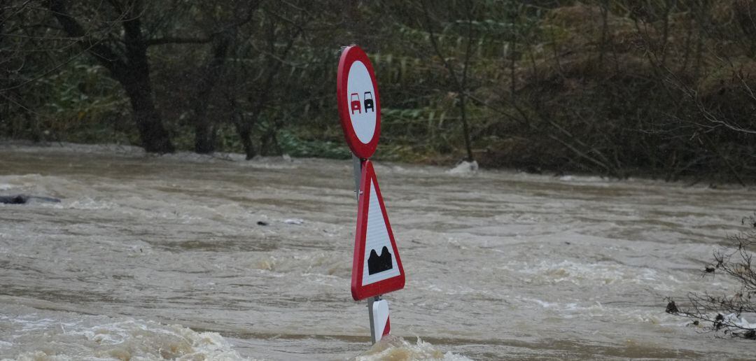 Una señal de tráfico sobresale de una vía totalmente inundada
 