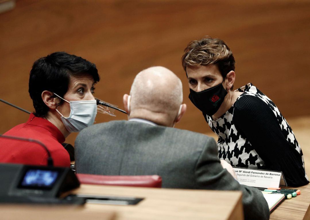 La presidenta del Gobierno de Navarra María Chivite (d), la consejera de Economía y Hacienda, Elma Saiz (i), junto al vicepresidente segundo y consejero de Ordenación del Territorio, José maría Aierdi (c), en un receso del Pleno del Parlamento