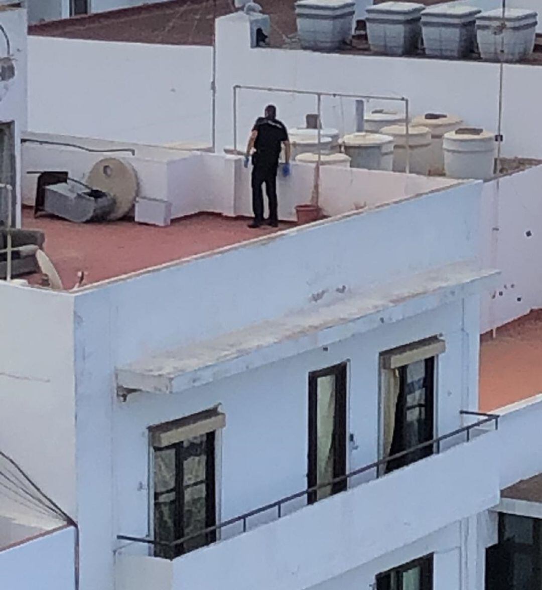 Uno de los agentes de la Policía Nacional en la azotea de la vivienda buscando a los okupas.