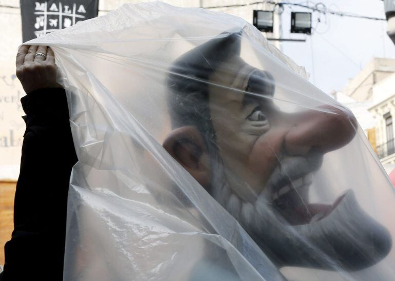 GRA118 VALENCIA, 13/03/2015.- Un ninot que representa al presidente del Gobierno, Mariano Rajoy, es tapado con plásticos por la amenaza de lluvia que pronostica la AEMET para este fin de semana en la Comunidad Valenciana. EFE/Juan Carlos Cárdenas