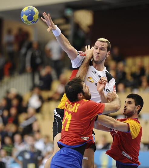 El alemán Pascal Hensr (c) se disputa el contrl de la pelota con el español Joan Canellas Reixach, (i), durante el partido del mundial de balonmano, grupo A, España vs Alemania, disputado en Kristianstad, Suecia, hoy, lunes, 17 de enero de 2011