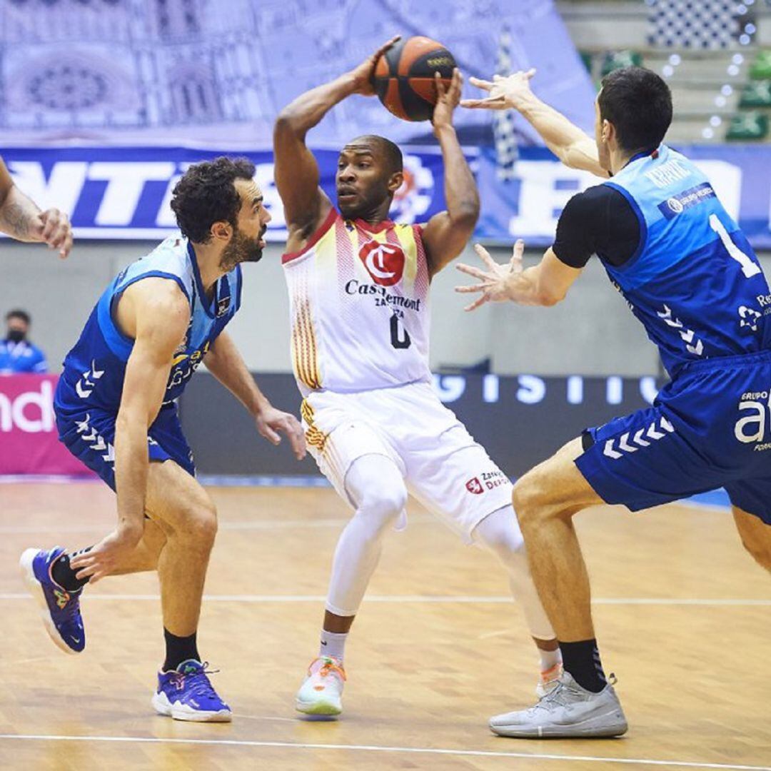 Sulaimon, momentos antes de realizar un pase ante la presión de dos jugadores rivales