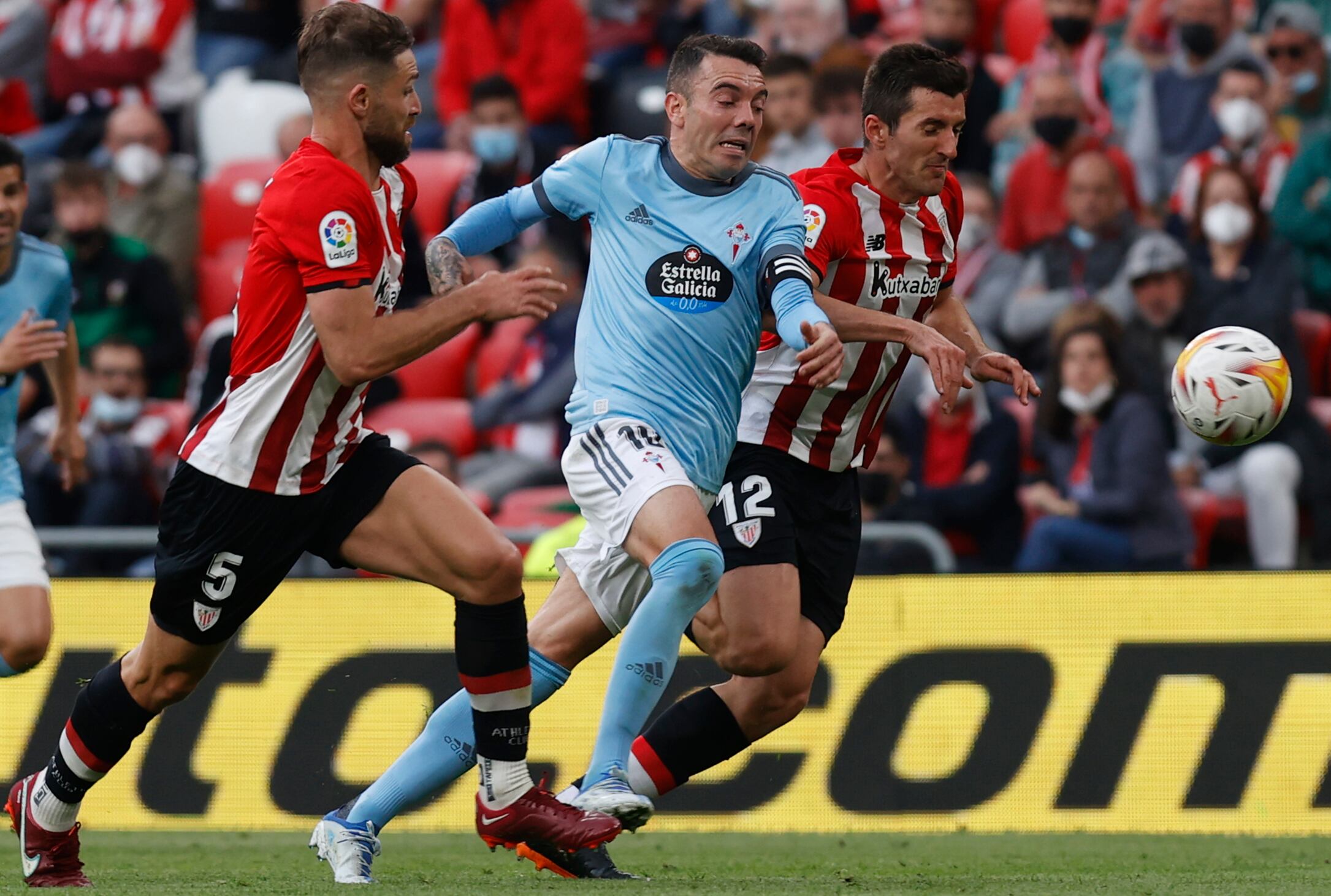 BILBAO, 17/04/2022.- El delantero del Celta de Vigo Iago Aspas (c) lucha con Yeray Álvarez (i) y conDaniel Vivian, ambos del Athletic de Bilbao, durante el encuentro de la jornada 32 de Liga en Primera División que se juega hoy domingo en San Mamés. EFE/Miguel Toña
