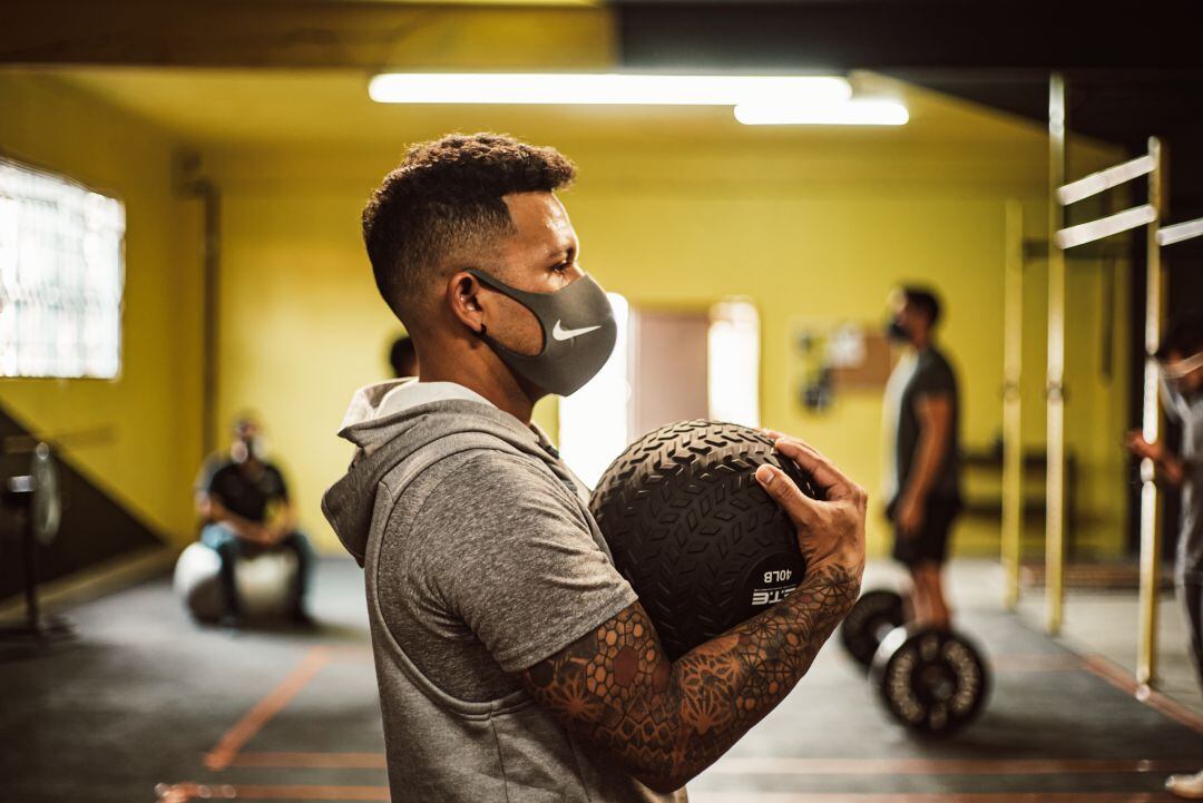 Un hombre practica deporte en un gimnasio con mascarilla, en una imagen de archivo