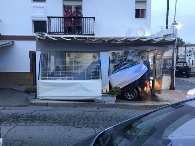 El coche, empotrado en la terraza del bar.