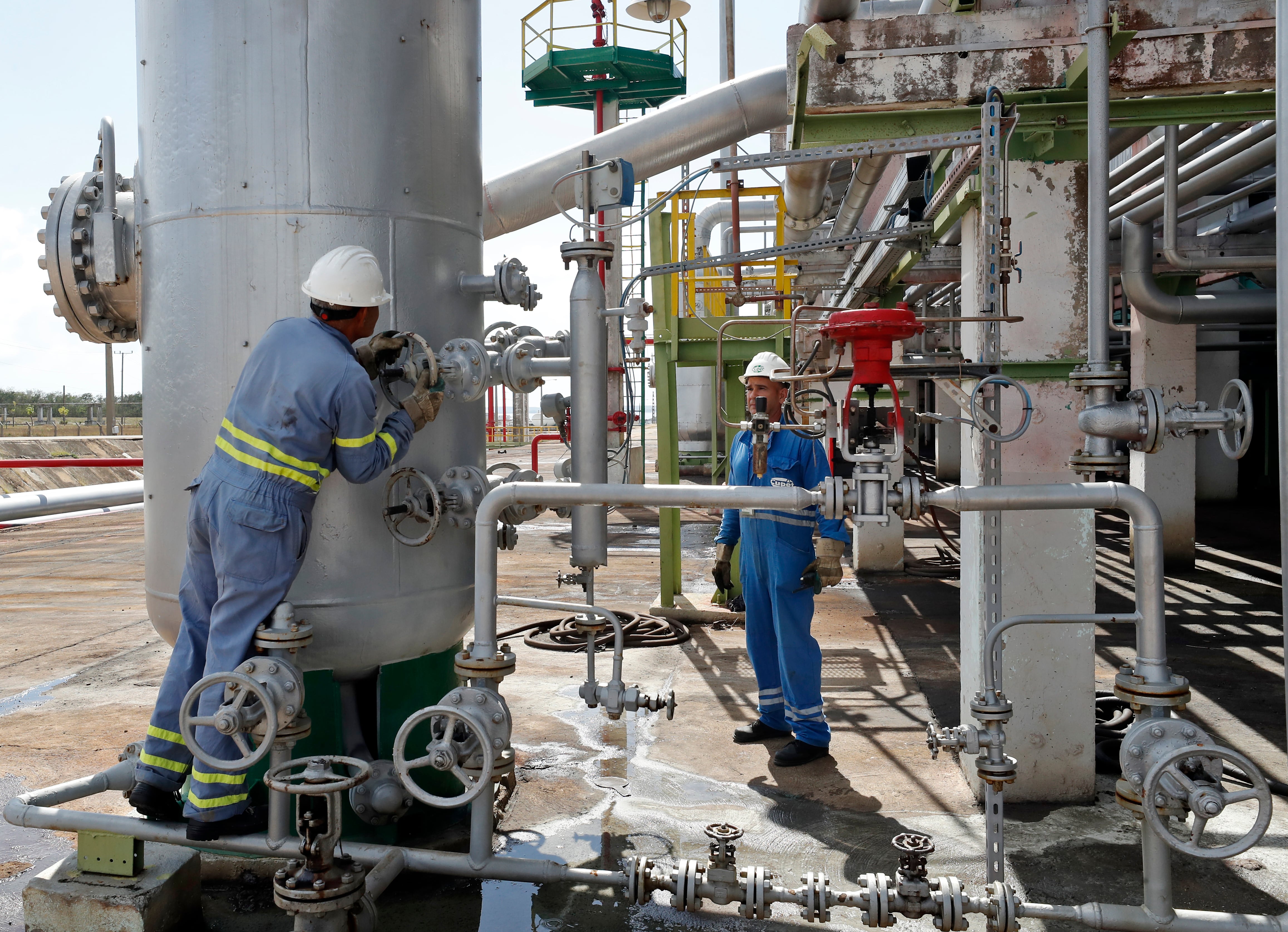 AME1031. LA HABANA (CUBA), 02/02/2023.- Fotografía que muestra trabajadores en la refinería de petróleo Camilo Cienfuegos hoy, en Cienfuegos (Cuba). La refinería de petróleo y sus derivados, ubicada en la ciudad de Cienfuegos, a unos 250 kilómetros al sudeste de La Habana, es hoy uno de los pilares fundamentales en el proceso de cambio de la matriz energética del Caribe, bajo los acuerdo del ALBA y PetroCaribe, impulsados por Cuba y Venezuela. EFE/Ernesto Mastrascusa
