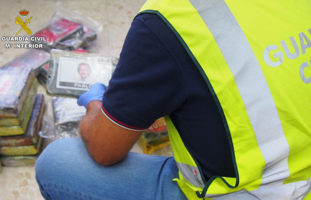 Un agente de la Guardia Civil analiza la documentación y la droga incautadas en el control de carretera en la A-92 en Granada