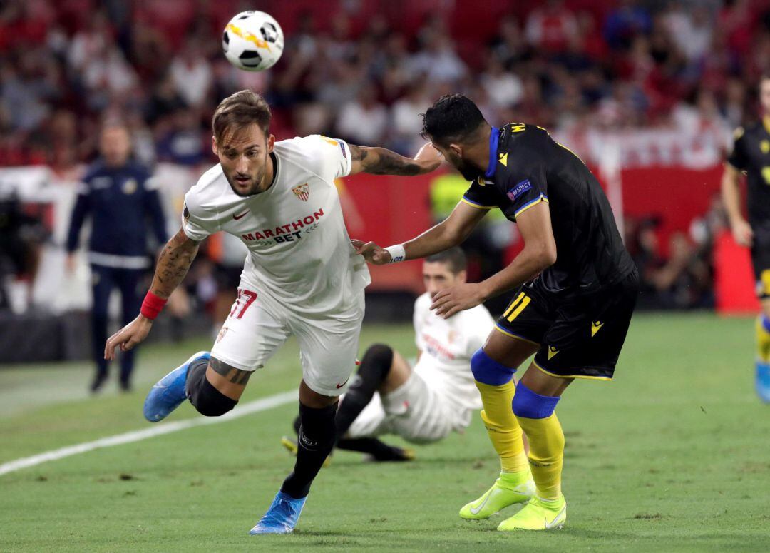 El centrocampsita serbio del Sevilla Nemanja Gudelj (i), y el delantero del Apoel Musa Suleiman luchan por el balón durante el partido de la segunda jornada de la fase de grupos de la Liga Europa que disputan en el estadio Sánchez Pizjuán