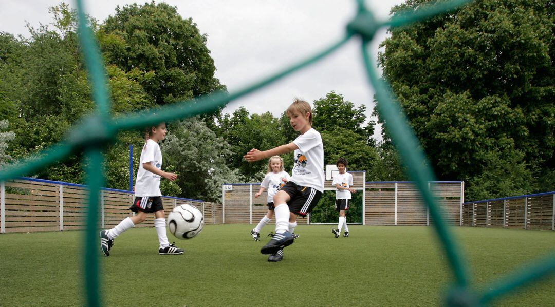 Niños jugando al fútbol al aire libre
