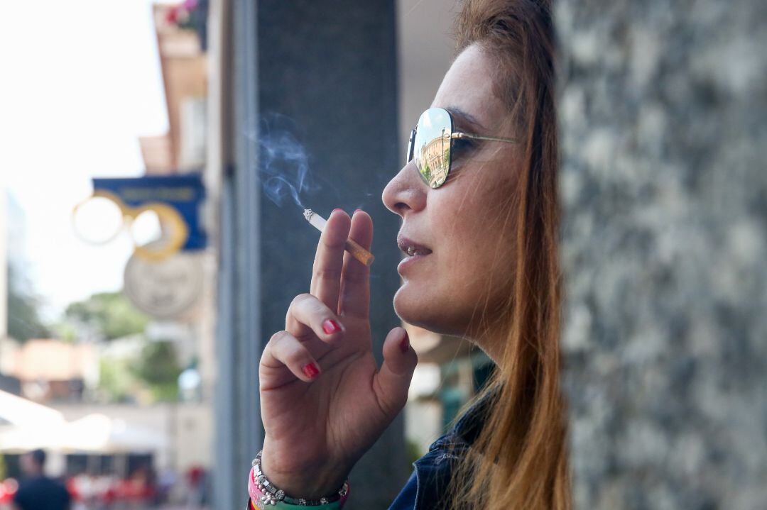 Mujer fumando un cigarro.