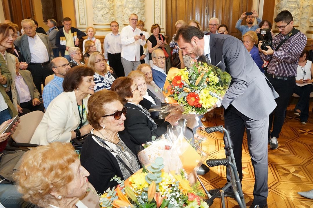 El alcalde entre un ramo de flores a las personas centenarias de Valladolid