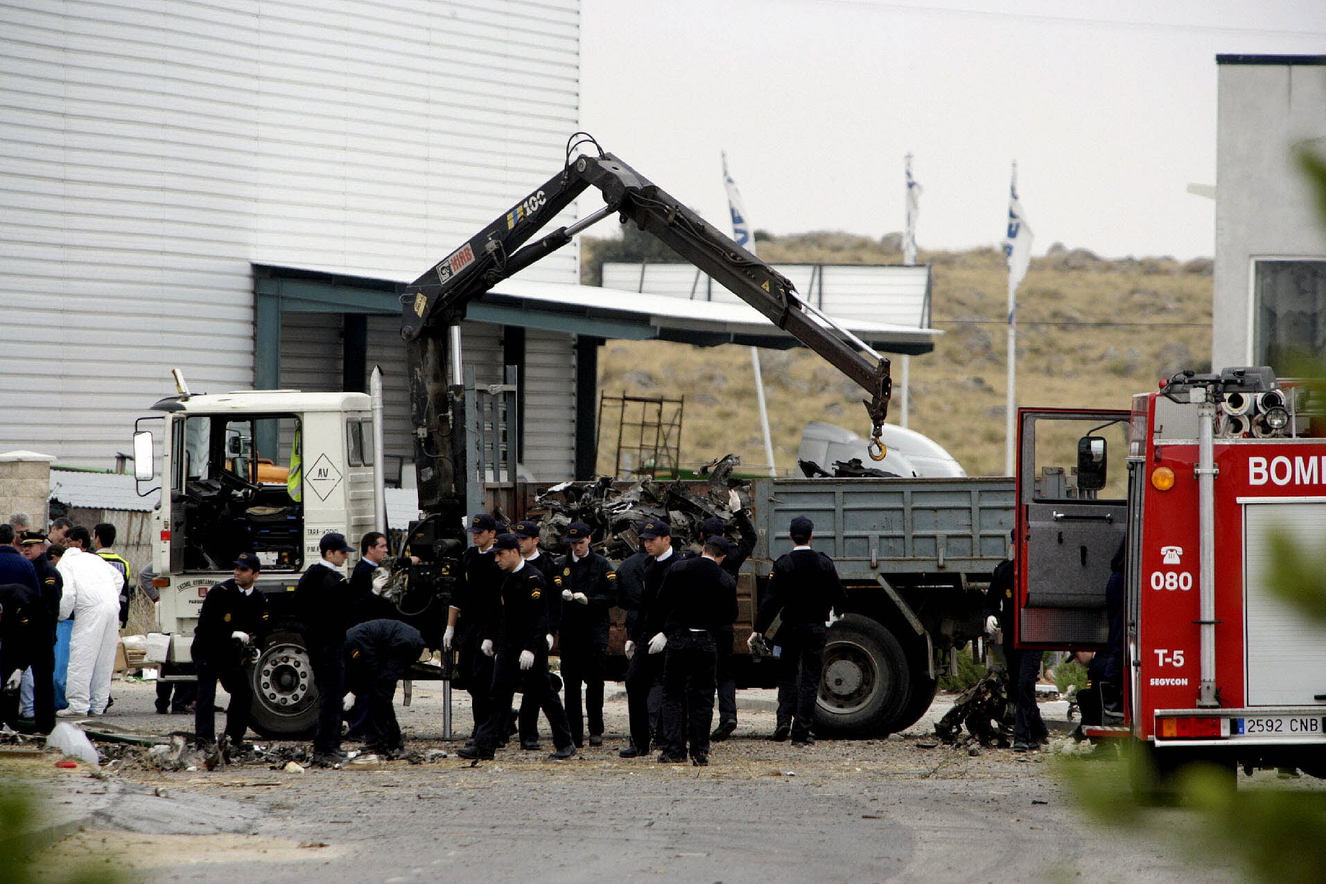 Agentes de la Policía Nacional inspeccionan el lugar del atentado perpetrado  por la banda terrorista ETA en el Polígono Industrial de Vicolozano, situado a 5 kilómetros de la capital.