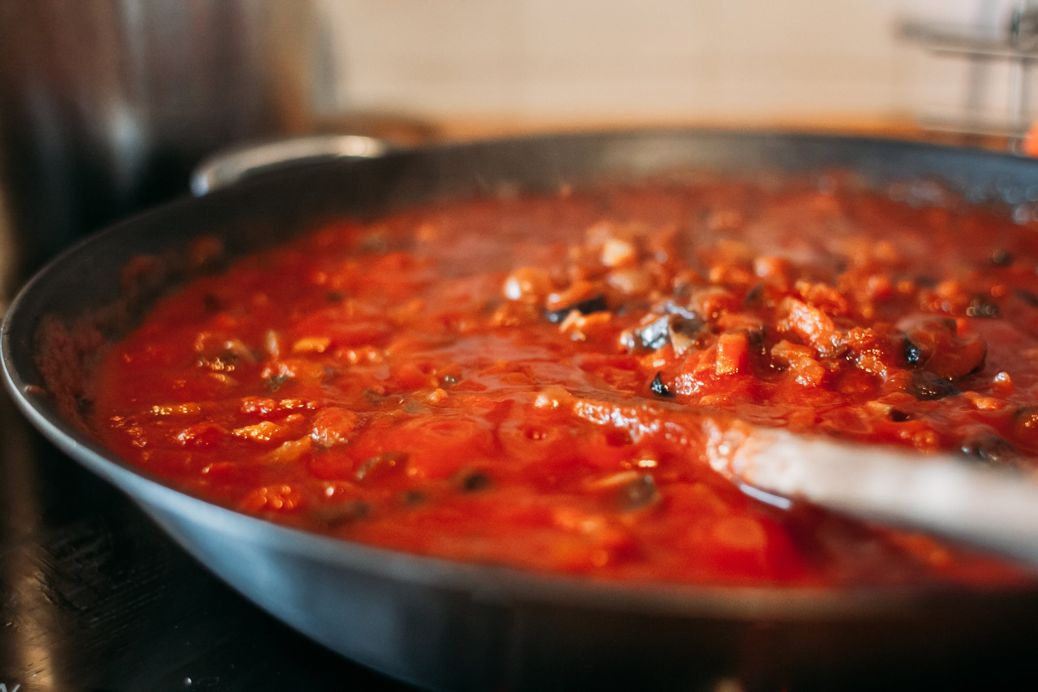 Cocinando una salsa de tomate con vegetales.