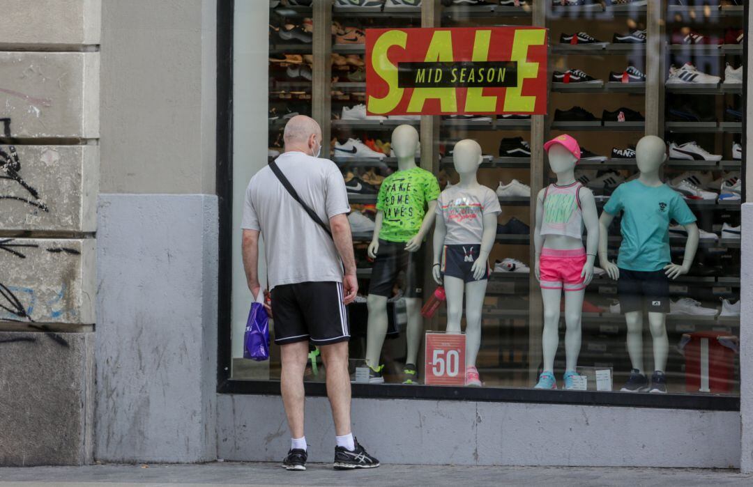 Un hombre mira el escaparate de una tienda de deportes en Madrid.