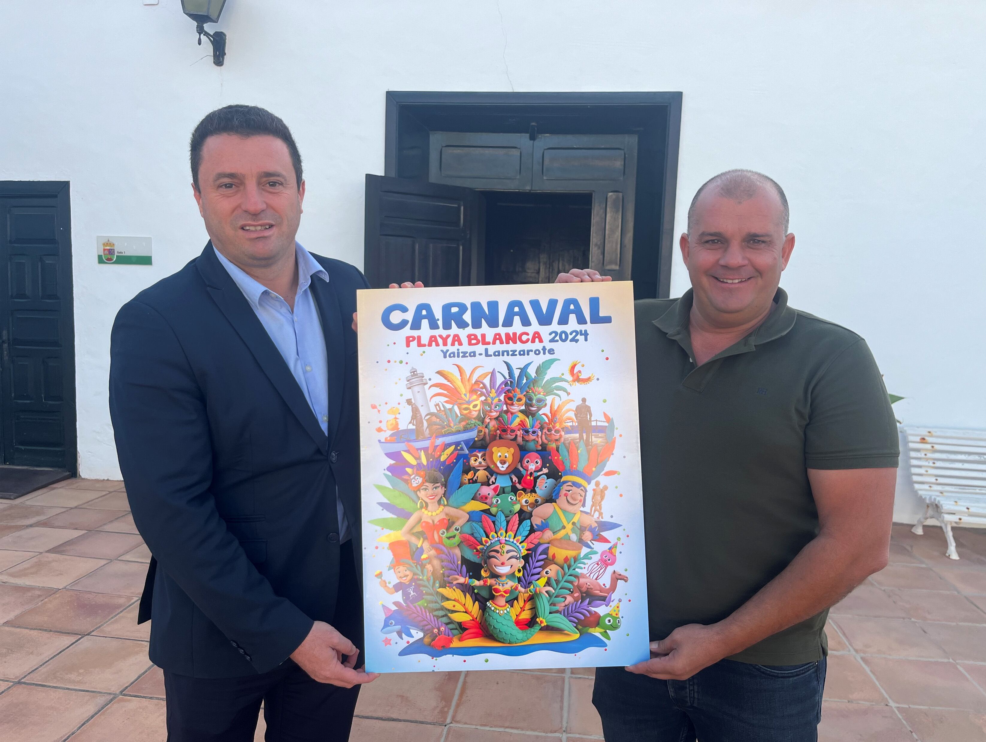 Óscar Noda, alcalde de Yaiza, junto a Javier Camacho, concejal de Festejos, sujetando el cartel del Carnaval 2024.