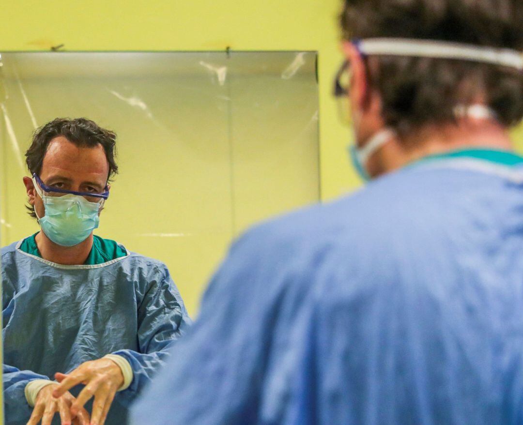 Un sanitario se lava las manos.