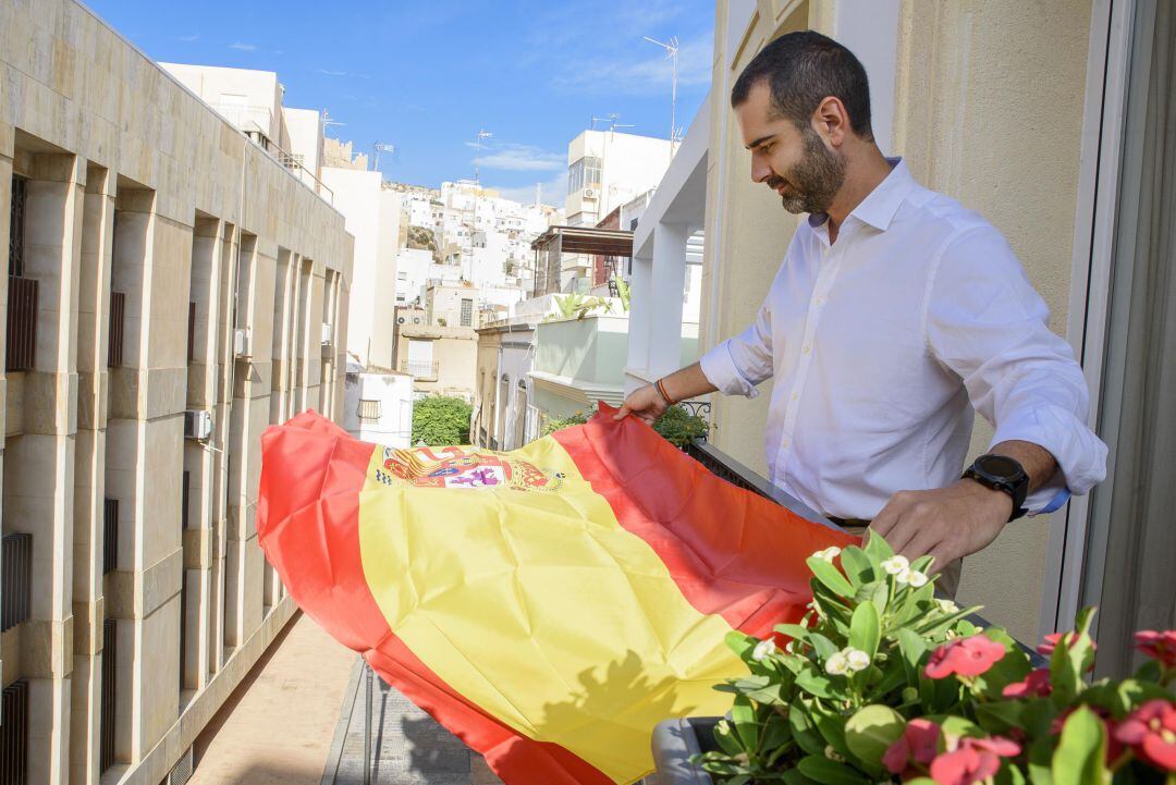 Ramón Fernández-Pacheco, alcalde de Almería, colocando una bandera en su balcón.