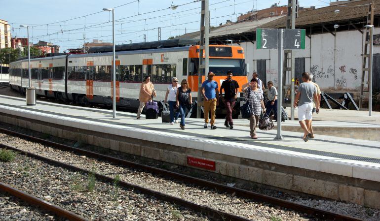 Passatgers baixant d'un tren de la línia R16 de RENFE.