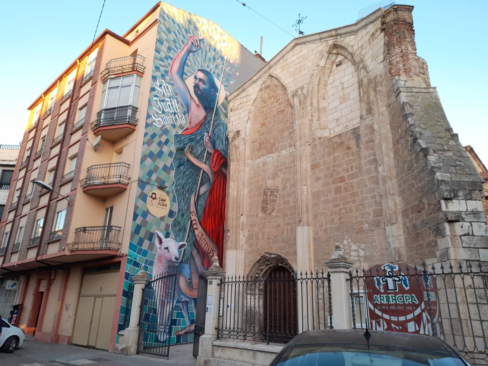 El mural de Nano Lázaro da la bienvenida en la entrada del templo arandino de San Juan de la Vera Cruz