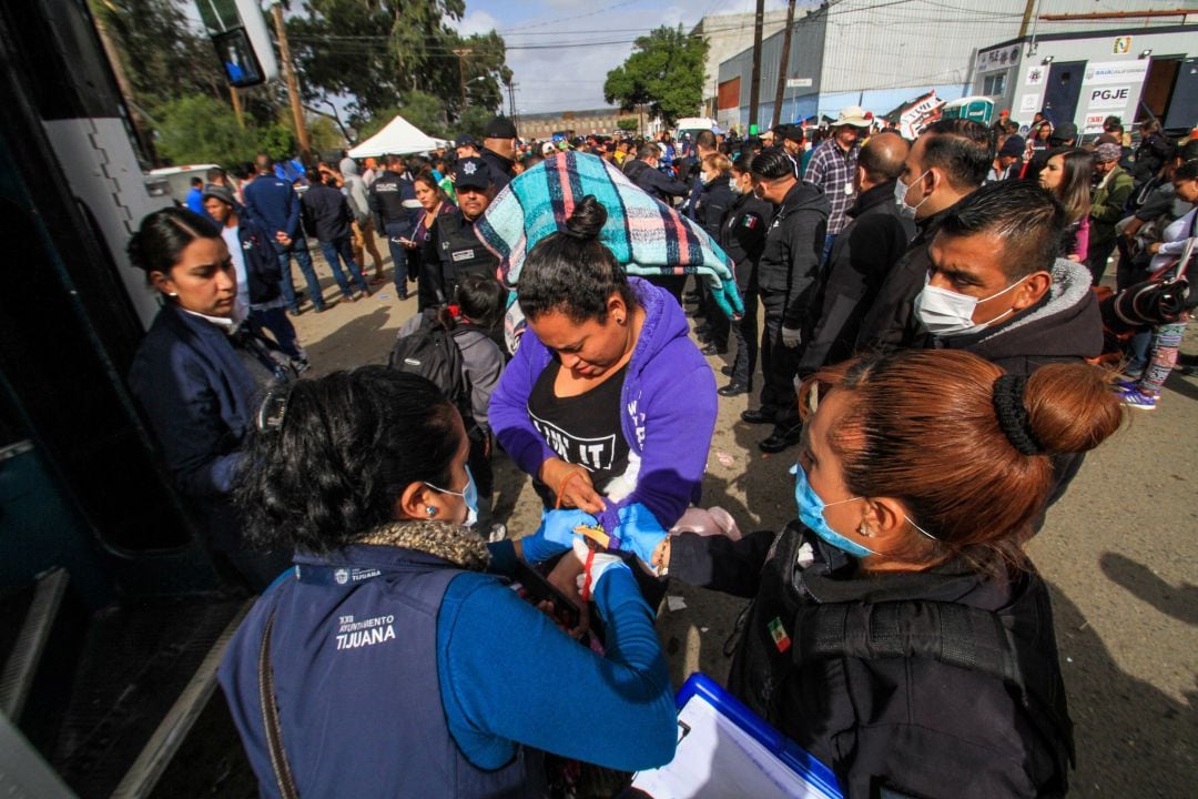 Integrantes de una caravana migrante de centroamericanos abandonando  el centro deportivo en el que se alojaban en Tijuana