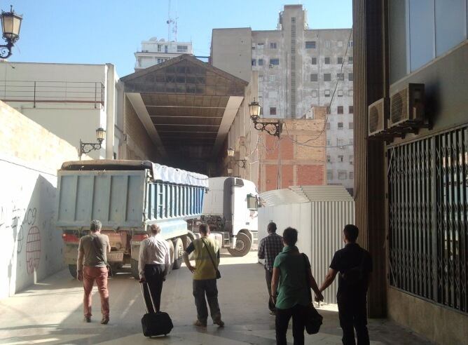 Un camión de obra entrando en el pasaje Doctor Serra bajo la atenta mirada de los viandantes