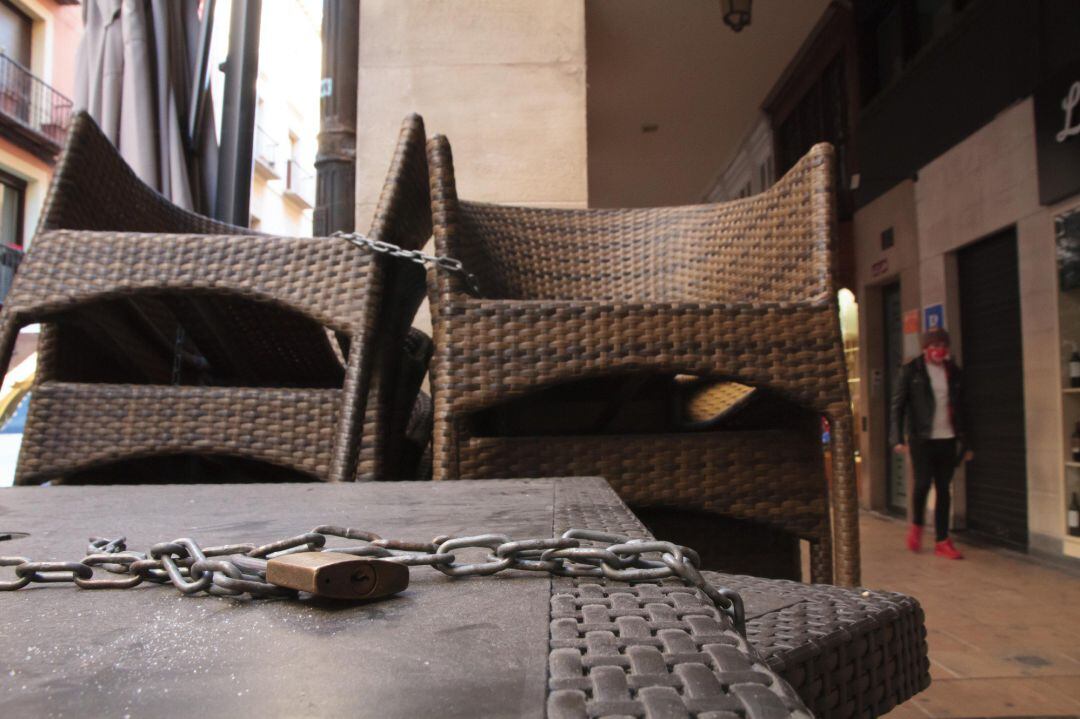 Un candado sostiene varias meses de un establecimiento cerrado